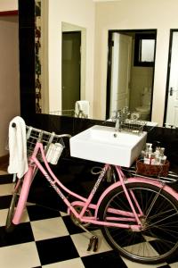 a pink bike in a bathroom with a sink at Casa Forno Country Hotel in Otjiwarongo