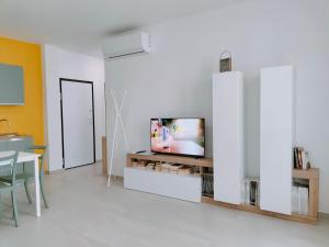 uma sala de estar com televisão numa parede branca em FaCentro - Pratico flat in centro storico em Faenza