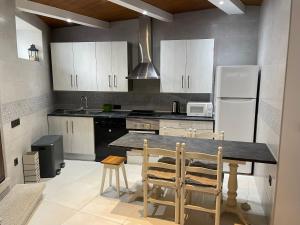 a kitchen with a table and a refrigerator at Casa Divarro in O Grove