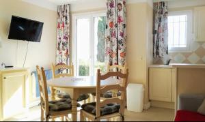 une salle à manger avec une table et des chaises et une fenêtre dans l'établissement joli 2 pieces vue mer , piscine proche ste Maxime résidence BELLEVUE, à Roquebrune-sur Argens