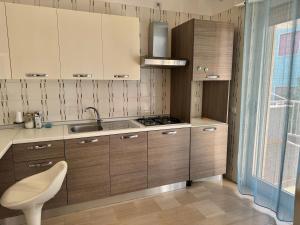 a kitchen with wooden cabinets and a sink at Villa Pavone in Ginosa Marina +103 photos