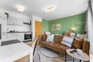 a living room with a couch and a kitchen at NEUE moderne Apartments nahe Uni, zentral in Cottbus