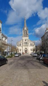 a large white building with a clock tower on a street at Chez Eric le n2 in Tours