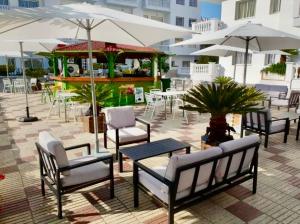 a group of chairs and tables with umbrellas on a patio at Apartamento Europa con terraza in Blanes