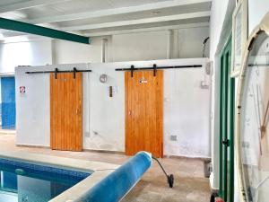 een zwembad met twee houten deuren in een kamer bij Cave Houses Ed Yara and Nadieh with PRM facilities in Margen de Abajo