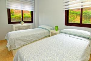 2 Betten in einem Zimmer mit 2 Fenstern in der Unterkunft Holiday flat Mijas Costa - COS02106b-P in Mijas Costa