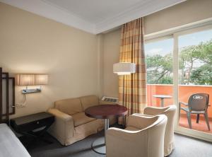 Crowne Plaza Rome St. Peter's, an IHG Hotel في روما: غرفه فندقيه بسرير واريكه وطاولة