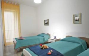 a bedroom with two beds and a table with flowers on it at Villa Pavone in Ginosa Marina