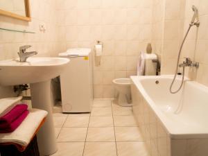 a bathroom with a sink and a tub and a toilet at Sopot Apartament in Sopot