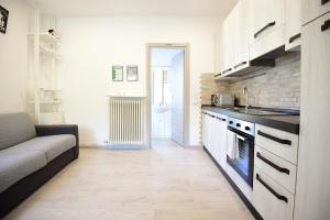 a kitchen with a couch and a stove top oven at La Casa dei Laghi 1 Comabbio Monate Maggiore Orta in Mercallo