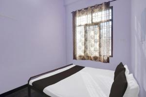 biała sypialnia z łóżkiem i oknem w obiekcie OYO Flagship Aravali Guest House & Restaurant w Kishangarh