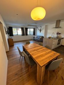 a kitchen and living room with a wooden table and chairs at Our's Living in Hollersbach im Pinzgau