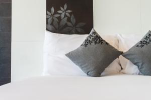 Una cama con cuatro almohadas encima. en Marigold Celebration hotel, en Rāipur