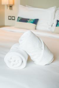 Una toalla blanca sobre una cama en Marigold Celebration hotel, en Rāipur