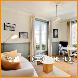 Suite Haussmann by Les Maisons de Charloc Homes في باريس: غرفة معيشة مع أريكة وطاولة