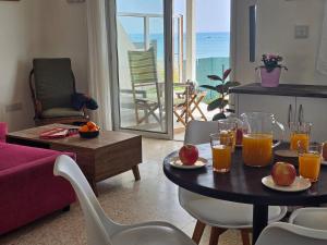 a living room with a table with glasses of orange juice at Ammos Beachfront Villa Paradise in Larnaca