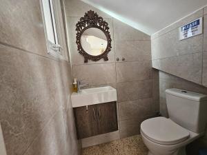 a bathroom with a toilet and a sink and a mirror at Ammos Beachfront Villa Paradise in Larnaca +42 photos
