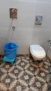 a bathroom with a toilet and a blue bucket at Hotel Mohan Family-Friendly Hotels @ New Delhi Railway Station in New Delhi