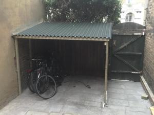 a bike parked in a garage next to a building at Peaceful garden view double with ensuite in house opposite beach, with access to private garden and bike store in Kent