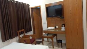 a room with a desk and a tv and a bed at Hotel Mohan Family-Friendly Hotels @ New Delhi Railway Station in New Delhi