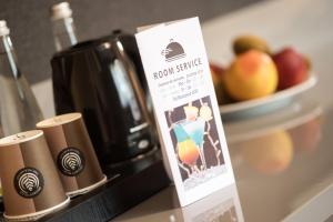 a sign on a counter with a coffee pot and fruit at SeaPark Hotel Wellness & Spa in Kołobrzeg