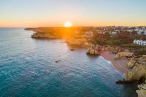 eine Luftansicht auf einen Strand bei Sonnenuntergang in der Unterkunft Vila Gale Nautico in Armação de Pêra