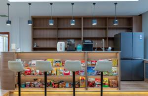 a kitchen with two chairs and a counter with food at Shisandufu Youth Hostel in Xi'an