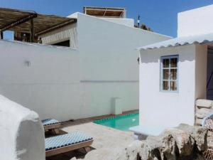 a white house with a swimming pool next to a building at Katonkel in Paternoster