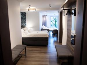 Cette chambre comprend 2 lits et un canapé. dans l'établissement Hotel KUMP365, à Paderborn