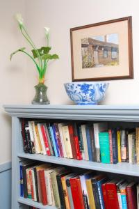 a book shelf filled with books and a vase of flowers at Deerfield Inn in Deerfield