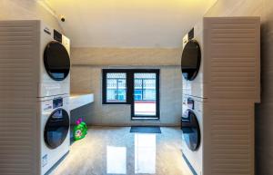 a laundry room with two washers and a window at Shisandufu Youth Hostel in Xi'an