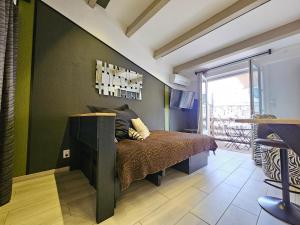 una camera con letto e parete verde di Appartement Style Loft - proche Village Naturiste a Cap d'Agde