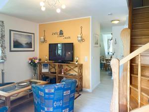 a living room with a television and a staircase at Achtern Diek 7b - Wohnung 8 in Groß Kirr