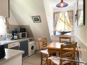 a kitchen with a table and a boat in the window at Achtern Diek 7b - Wohnung 8 in Groß Kirr