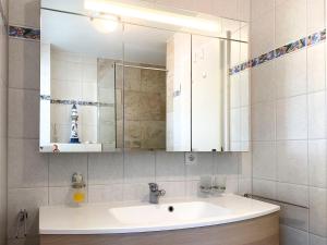 a bathroom with a sink and a mirror at Achtern Diek 7b - Wohnung 8 in Groß Kirr +15 photos