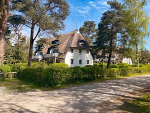 a large white house with a thatched roof at Achtern Diek 7b - Wohnung 8 in Groß Kirr