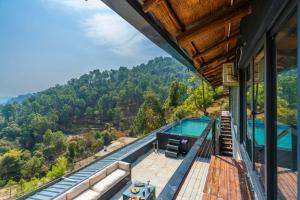 a house with a view of a swimming pool and mountains at StayVista at Leopard's Creek with Pool in Solan