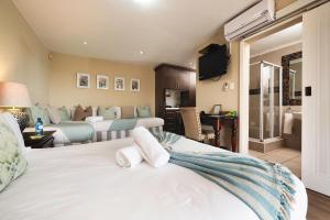 a bedroom with two beds and a living room at Nautilus Guesthouse in Port Elizabeth
