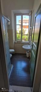La salle de bains est pourvue d'un lavabo, de toilettes et d'une fenêtre. dans l'établissement Casa Lucia, à Cupra Marittima