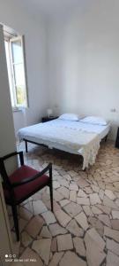 - un lit dans une chambre avec une chaise et une chaise dans l'établissement Casa Lucia, à Cupra Marittima