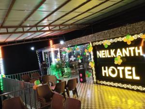 a hall with a hotel sign and chairs at Hotel Neilkanth in Chamba