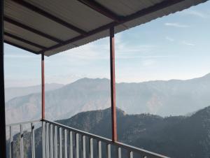 a view of the mountains from a balcony at Hotel Neilkanth in Chamba