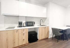 a kitchen with a sink and a microwave and a table at ANhome K11 serviced apartments Plus in Athens