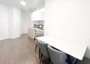 cocina blanca con mesa y sillas en ANhome K11 serviced apartments Plus, en Atenas