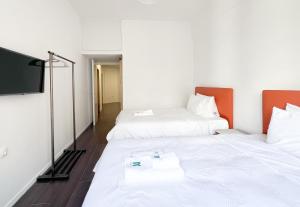 Habitación con 2 camas y TV de pantalla plana. en ANhome K11 serviced apartments Plus, en Atenas