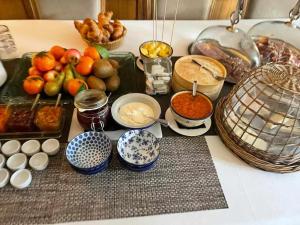 une table recouverte de bols de nourriture et d'autres denrées alimentaires dans l'établissement Le château brangoly, à Enveitg