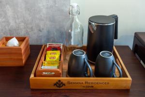 烏布的住宿－Semana Residences by Cove，一张带餐桌上咖啡机的木制托盘