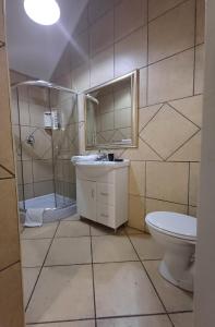 a bathroom with a sink and a shower and a toilet at Lauriston Guesthouse in Centurion