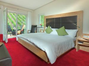 Schlafzimmer mit einem großen Bett und einem roten Teppich in der Unterkunft Hotel Zur Traube in Ürzig