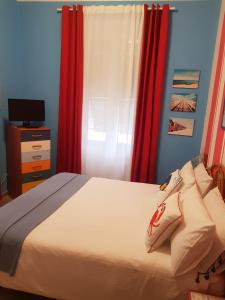- une chambre avec un lit et des rideaux rouges dans l'établissement Bibi a Mare, à Finale Ligure